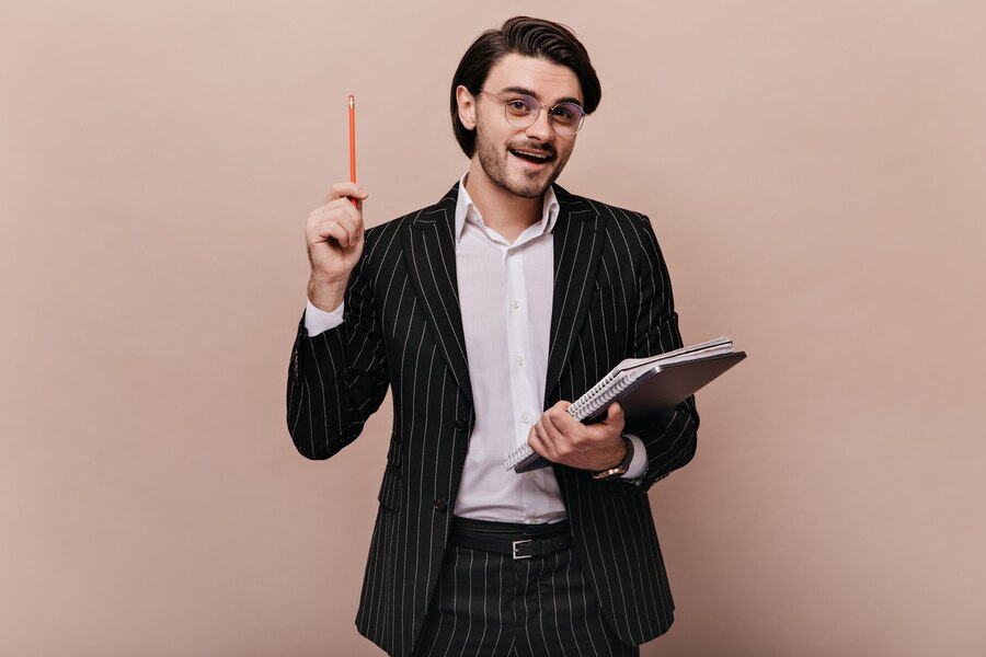elegant-young-teacher-with-brunette-hair-stylish-light-shirt-black-striped-suit-glasses-holding-writings-pen-giving-lecture_197531-24666