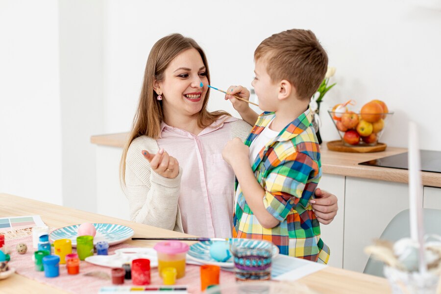 smiley-woman-son-painting-eggs_23-2148442991